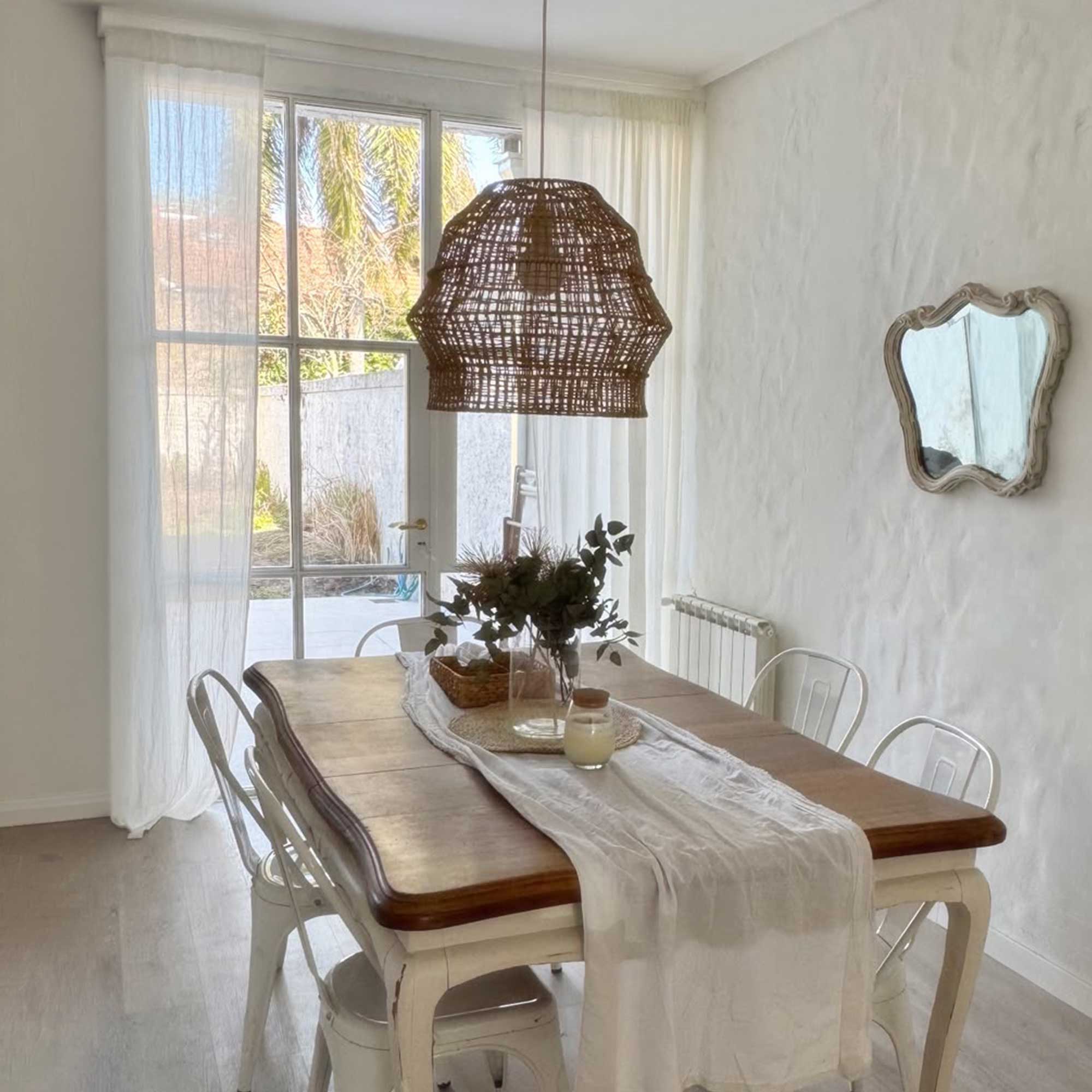 Cortinas de gasa en un comedor con mesa de madera